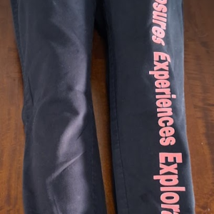 A Pair of Black Pants with Personal Logo  words on right leg that say (Exposure  Experiences  Exploration)  down right Pants leg
